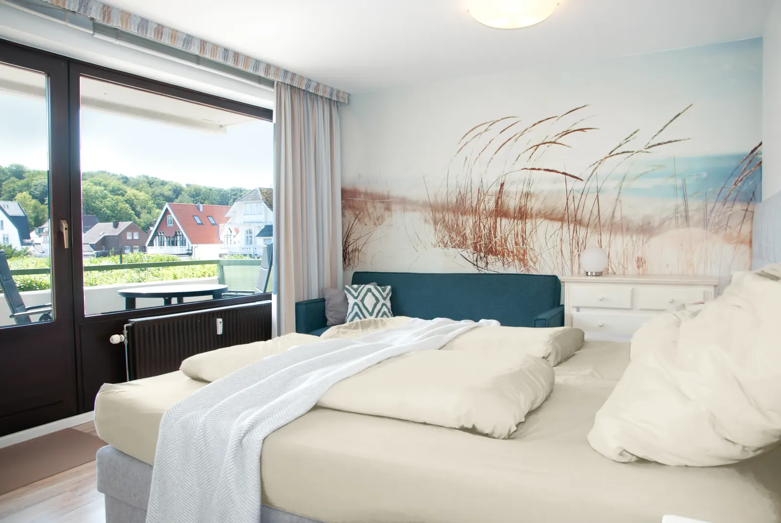 Schlafzimmer mit Boxspringbett und Tür zum Südbalkon